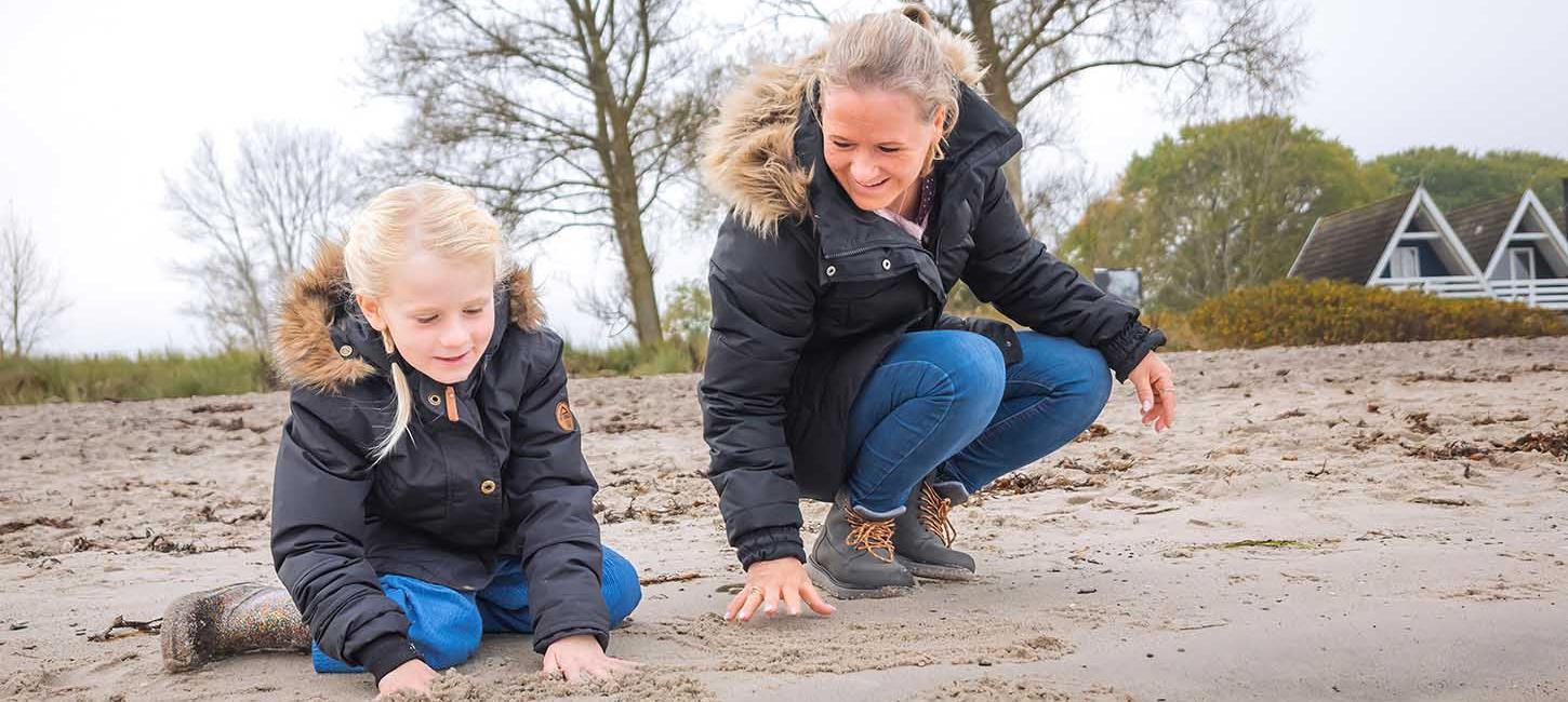 Mor og datter leger på Hasmark Strand i efterårs- og vintertiden